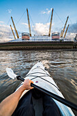 Kayaking on the River Thames past the O2 Arena, Greenwich, London, England