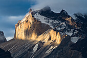 Sunset light illuminates the west face of Monte Almirante Nieto in the Paine Massif in Torres del Paine National Park, a UNESCO World Biosphere Reserve in Chile in the Patagonia region of South America.