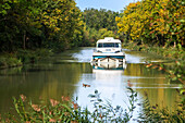 Der Canal du Midi, in der Nähe von Carcassonne, französisches Departement Aude, Region Occitanie, Languedoc-Rousillon Frankreich. Boote, die auf dem von Bäumen gesäumten Kanal vertäut sind. Die Schleuse von Herminis oder Herminis ecluse.