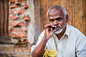 Porträt eines Zigarre rauchenden Mannes in den Straßen von Negombo an der Westküste von Sri Lanka, Asien
