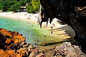 Tourist on Beautiful, Tropical, Ao Phra Nang Beach, Railay (Rai Leh), South Thailand. Railay Beach (Rai Leh Beach) area is a stunning Thai holiday destination near Krabi, on the Andaman Coast of Thailand. The tropical paradise of Railay (Rai Leh), only accessible by traditional Thai boat due to being surrounded by enormous rocky limestone karsts, is home to a number of beautiful exotic beaches including Ao Phra Nang, East Railay, and West Railay Beach.