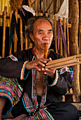 Man playing a type of flute at Baan Tong Luang, village of Hmong people in rural Chiang Mai province, Thailand.