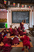 Mönch unterrichtet junge Mönchsanfänger in einem buddhistischen Tempel in Pindaya, Shan-Staat, Myanmar (Burma)