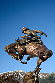 Attitude Adjustment, Bronzeskulptur eines Cowboys und eines bockenden Broncos von Austin Barton in der Innenstadt von Joseph, Oregon.