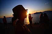 People enjoying views of Mykonos town at sunset, Greece