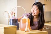 Young Asian-American woman concentrates on food science experiment, College Park, Maryland