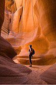 Woman hiker in Canyon X, a slot canyon on the Navajo Reservation near Page, Arizona.
