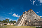 Die Westfassade der Pyramide des Magiers, die auch als Pyramide des Zwerges bekannt ist, weist auf das Vogelviereck. Sie ist das höchste Bauwerk in den prähispanischen Maya-Ruinen von Uxmal, Mexiko, und ragt etwa 35 Meter in die Höhe. Der Tempel am oberen Ende der Treppe ist im Chenes-Stil erbaut, während der obere Tempel im Puuc-Stil gehalten ist.