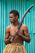 Inosi Navoto with warrior club greeting visitors to Lawai Pottery Village on Viti Levu Island, Fiji.