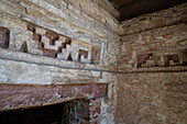 Laubsägearbeiten aus Stein im mixtekischen Stil mit roter Originalfarbe am Eingang zu Grab 1, der Grabstätte von Lord Nine Flower, in den Ruinen der zapotekischen Stadt Zaachila im Zentraltal von Oaxaca, Mexiko.