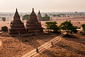 Touristen erkunden die Tempel von Bagan (Pagan) bei Sonnenaufgang, Myanmar (Birma)