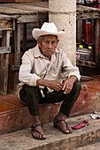 Ein indigener Maya-Mann sitzt auf dem Markt in Muna, Yucatan, Mexiko.