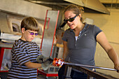Besucher, die in der Jennifer L. Sears Glass Foundry in Lincoln City an der zentralen Küste von Oregon einen Glaswagen herstellen.