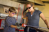 Visitor making a glass float at the Jennifer L. Sears Glass Foundry in Lincoln City on the central Oregon Coast.