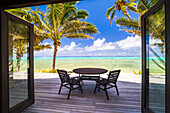 Luxuriöse Villa am Strand mit Meerblick, mit privatem Balkon mit Tisch und Stühlen neben tropischen Palmen und dem wunderschönen blauen Pazifik