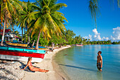 Ein Paar entspannt sich am Strand von Rangiroa, Tuamotu-Inseln, Französisch-Polynesien, Südpazifik.