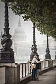 Couple on South Bank with St Paul's Cathedral behind, London, England