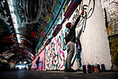 Graffitikünstler in den Waterloo Leake Street Graffiti Tunnels im Zentrum von London, England, Vereinigtes Königreich
