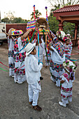 Frauen in traditionellen, festlich bestickten Huipils und geblümten Hüten bereiten sich auf den Tanz des Schweinekopfes und des Truthahns (Baile de la cabeza del cochino y del pavo) in Santa Eleana, Yucatan, Mexiko, vor. Dieser Festtanz der Maya wird nur einmal im Jahr aufgeführt.