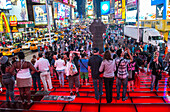 Touristen auf dem Times Square in New York City. Der Times Square ist ein wichtiger Handelsknotenpunkt in Midtown Manhattan und eine der meistbesuchten Touristenattraktionen der Welt.