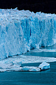 Die zerklüftete Wand des Perito-Moreno-Gletschers und der Lago Argentino im Los-Glaciares-Nationalpark bei El Calafate, Argentinien. Ein UNESCO-Weltnaturerbe in der Region Patagonien in Südamerika. Eisberge vom kalbenden Eis des Gletschers schwimmen im See.