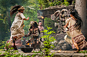Tänzerinnen und ein Mann, der Ah puch, den Herrn der Unterwelt (oder Gott des Todes), darstellt, während der Maya-Kulturvorführung "Los Rostros de Ek chuah" zu Ehren des Maya-Gottes des Kakaos im Park von Xcaret, Riviera Maya, Mexiko.