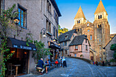 Das kleine mittelalterliche Dorf Conques in Frankreich. Es zeigt dem Besucher seine Abteikirche und die mit Schieferdächern gedeckten Häusergruppen. Durchquerung der engen Gassen und Monolith für die Gefallenen des Krieges im alten mittelalterlichen Dorf Conques am Ufer des Flusses Dordou