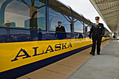 Alaska Railroad passenger car and conductor at Anchorage Airport train depot; Anchorage, Alaska.