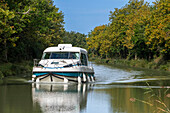The Canal du Midi, near Carcassonne, French department of Aude, Occitanie Region, Languedoc-Rousillon France. Boats moored on the tree lined canal. The Herminis lock or Herminis ecluse.