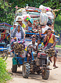 Burmese farmers riding on an old tractor in a village in Shan state Myanmar