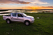 4wd bei Sonnenuntergang auf der Estancia San Juan de Poriahu, Ibera Wetlands, einem Sumpfgebiet in der Provinz Corrientes, Argentinien