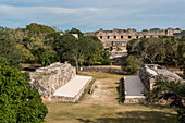 Blick auf den zeremoniellen Ballplatz mit dem Nonnenkloster dahinter in den prähispanischen Mayaruinen von Uxmal, Mexiko.