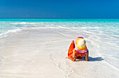 Frau mit Hut entspannt sich an idyllischem, leerem Strand, Sansibar, Tansania, Ostafrika, Afrika