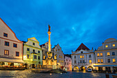 Fountain and Plague Column with traditional houses with gables in background at twilight, Namesti Svornosti Square in historical center, UNESCO World Heritage Site, Cesky Krumlov, Czech Republic (Czechia), Europe