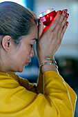 Huynh Dao Buddhist temple, woman at Buddhist ceremony praying with a candle, Chau Doc, Vietnam, Indochina, Southeast Asia, Asia
