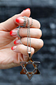 Close up on hands of woman with a Star of David (Jewish Star) pendant, Vietnam, Indochina, Southeast Asia, Asia