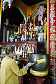 Rong Thanh Temple, Vietnamese Buddhist woman using a giant singing bowl, Tan Chau, Vietnam, Indochina, Southeast Asia, Asia