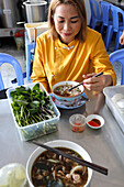 Woman eating traditional Vietnamese soup Pho, Tan Chau, Vietnam, Indochina, Southeast Asia, Asia