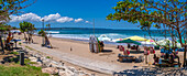 Blick auf Verkäufer und Surfbretter an einem sonnigen Morgen am Kuta Beach, Kuta, Bali, Indonesien, Südostasien, Asien