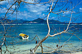 View Across Water With A Boat At Praslin On La Digue Island.