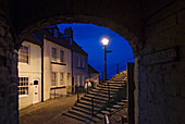 Abendlicher Blick durch den Torbogen der Häuser in der historischen Stadt Whitby.