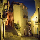 Beleuchtete Straßen in der Altstadt von Ibiza in der Abenddämmerung