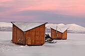 Schneemobil vor den kleinen Hütten des Abisko Ark Hotels