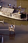 Menschen waschen sich in einem Holzboot auf dem Mekong