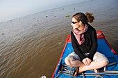 Junge Frau auf einem Boot im Mekong-Delta sitzend