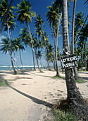 Palmen und das Schild "Mülltonnen bitte! Schild am Galera Point Strand