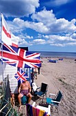 Family Outside Beach Hut With British Flags