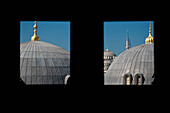 Turkey, Looking out window and across domed roofs of Haghia Sophia to Sultanahmet or Blue Mosque; Istanbul