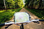 Cyclist With Map Following A Cycle Route Around Brockenhurst, New Forest National Park