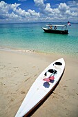 Fishing Boat Anchored Near Kayak On Beach